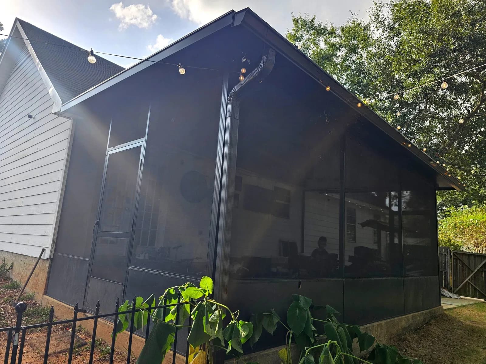 Bronze aluminum screen room exterior with a gable roofline and string lights, Daphne AL.