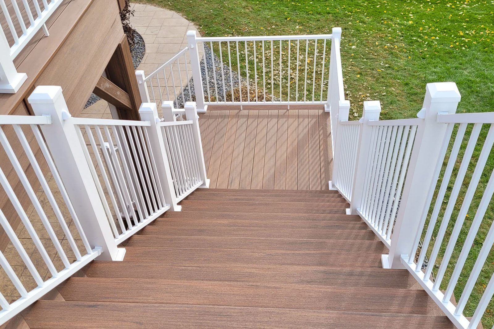 White Westbury aluminum railing with tear-drop baluster detail along deck stairs.